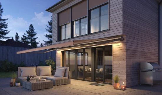 Moderne Terrasse mit gemütlicher Sitzgruppe und Beleuchtung bei Abenddämmerung